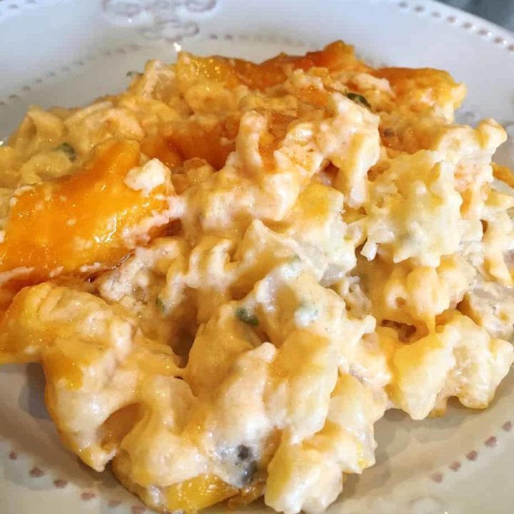 Cheesy funeral potato serving on a white dinner plate.