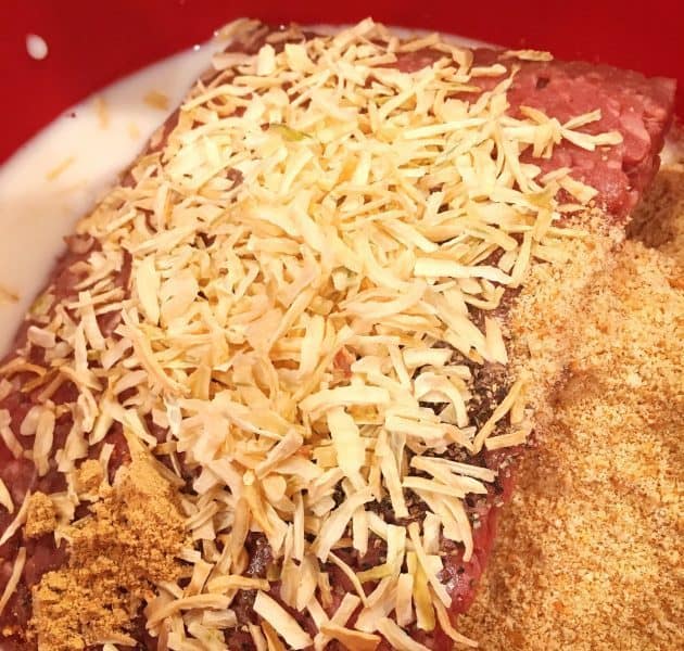 Dried Onions, bread crumbs, milk, and ground beef in bowl for Meat loaf