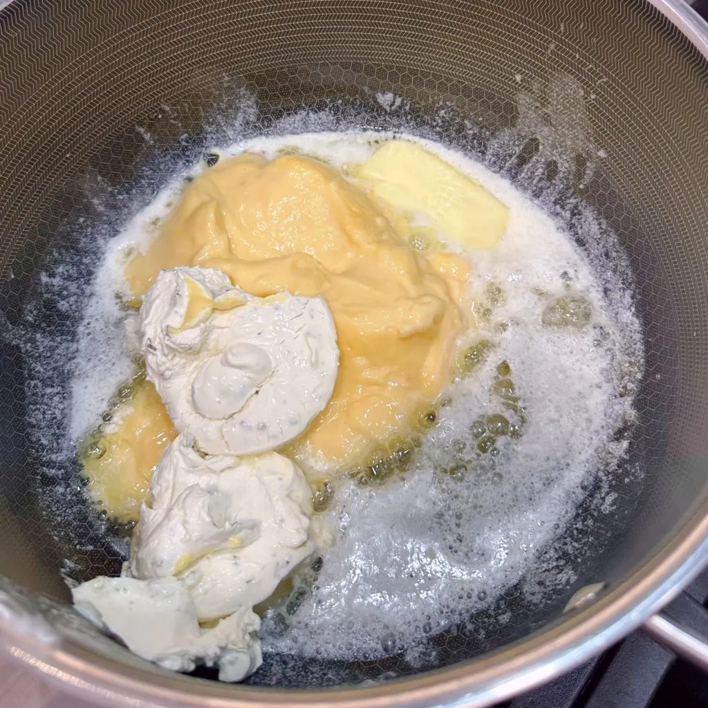 Adding butter, cream cheese, and soup in a large pot over medium heat.
