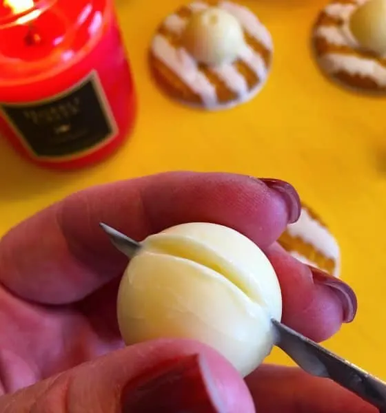 Using a hot knife to cut Lindor Truffle in half for bonnet hat