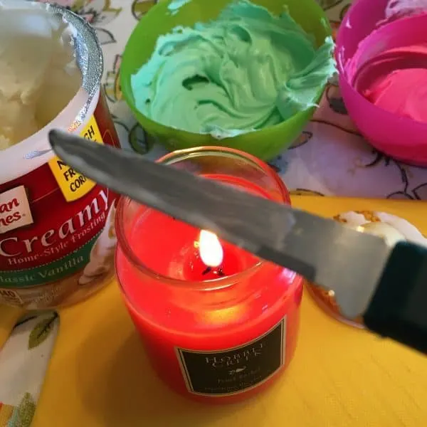Heating up a knife over a candle and colored frostings