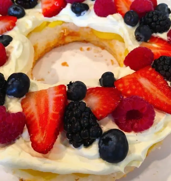 Placing fresh berries on top of lemon whipped cream frosting