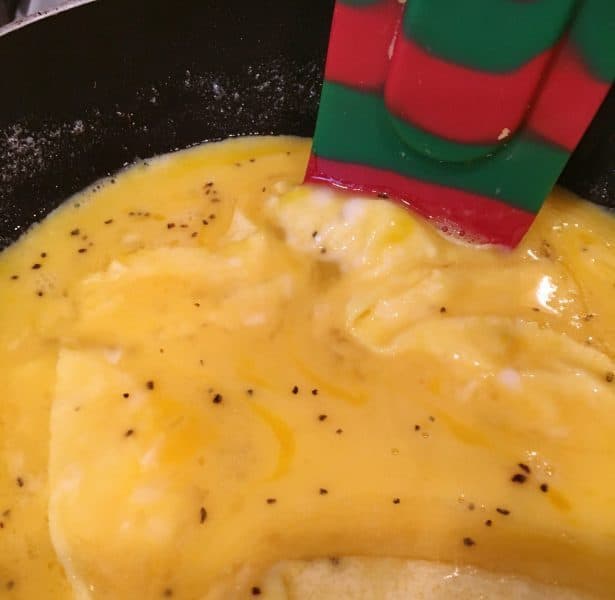 Pushing the edges of the eggs towards the center for an Omelet