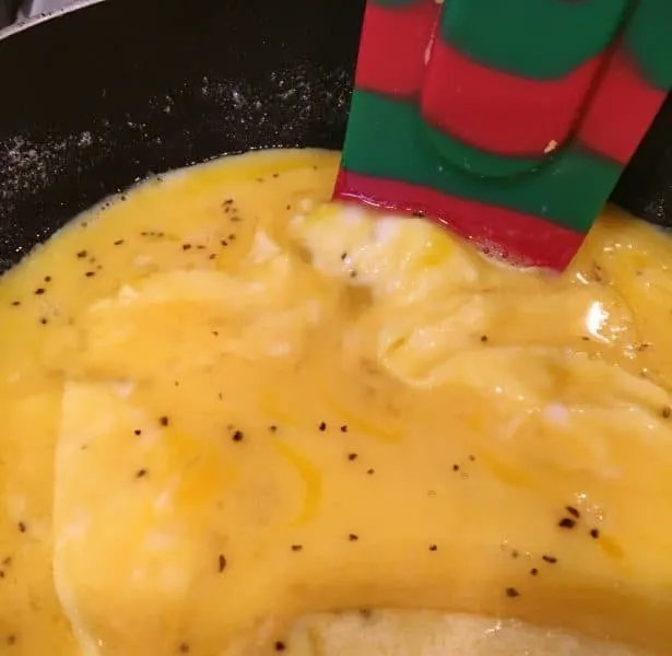 Pushing the edges of the eggs towards the center for an Omelet