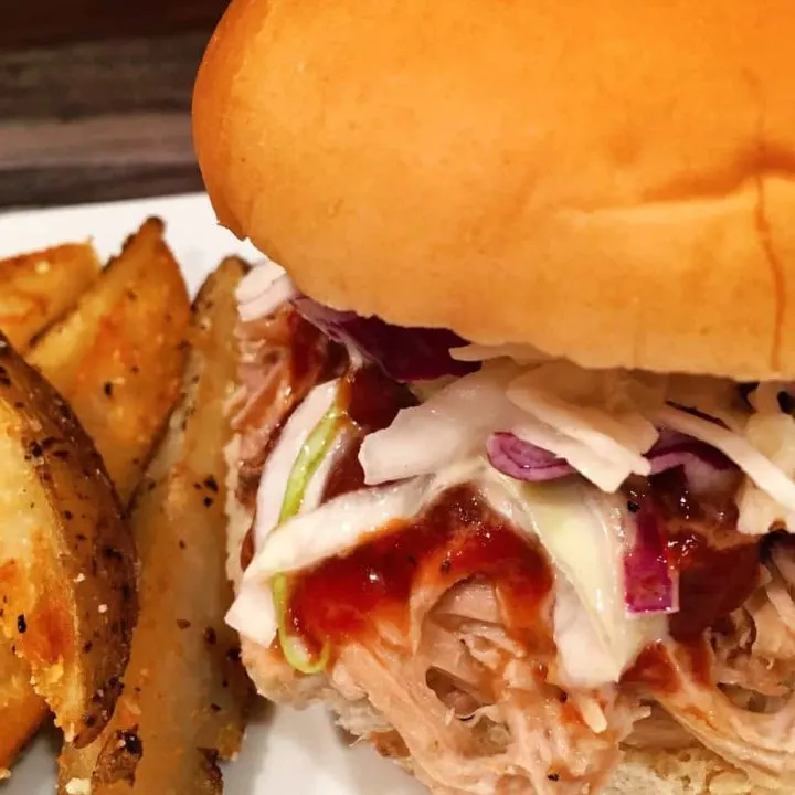 Pulled pork sandwich with potato wedges.