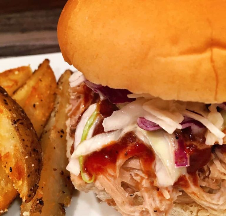 Pulled pork sandwich with potato wedges.