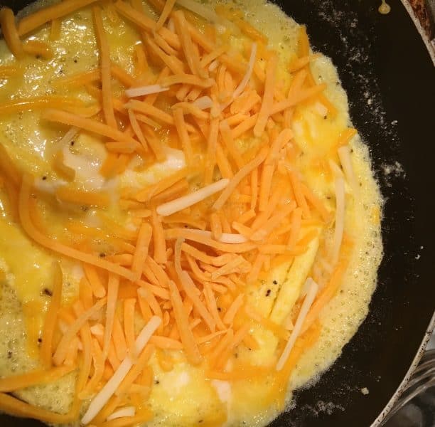 adding cheese on the inside of the omelet