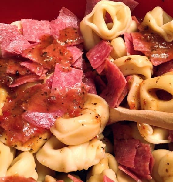 Adding Salami and Italian Dressing with Olives and Tortellini's