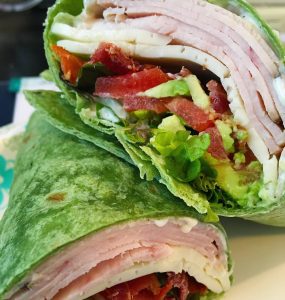 Turkey, tomatoes, cheese, bacon and lettuce wrapped up in a tortilla