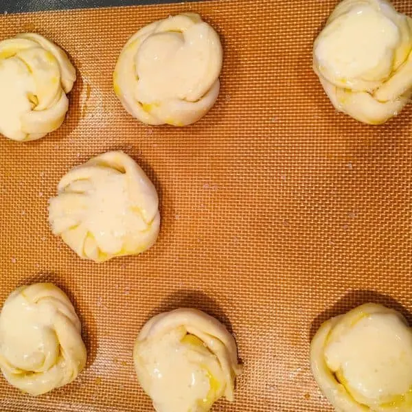 twist puff strips into roses topped off with cream cheese topping