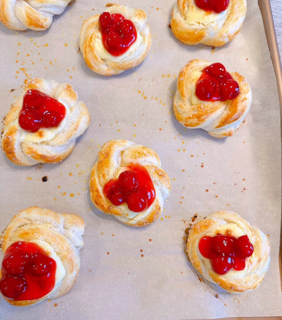Baked cherry pastries on the baking sheet.