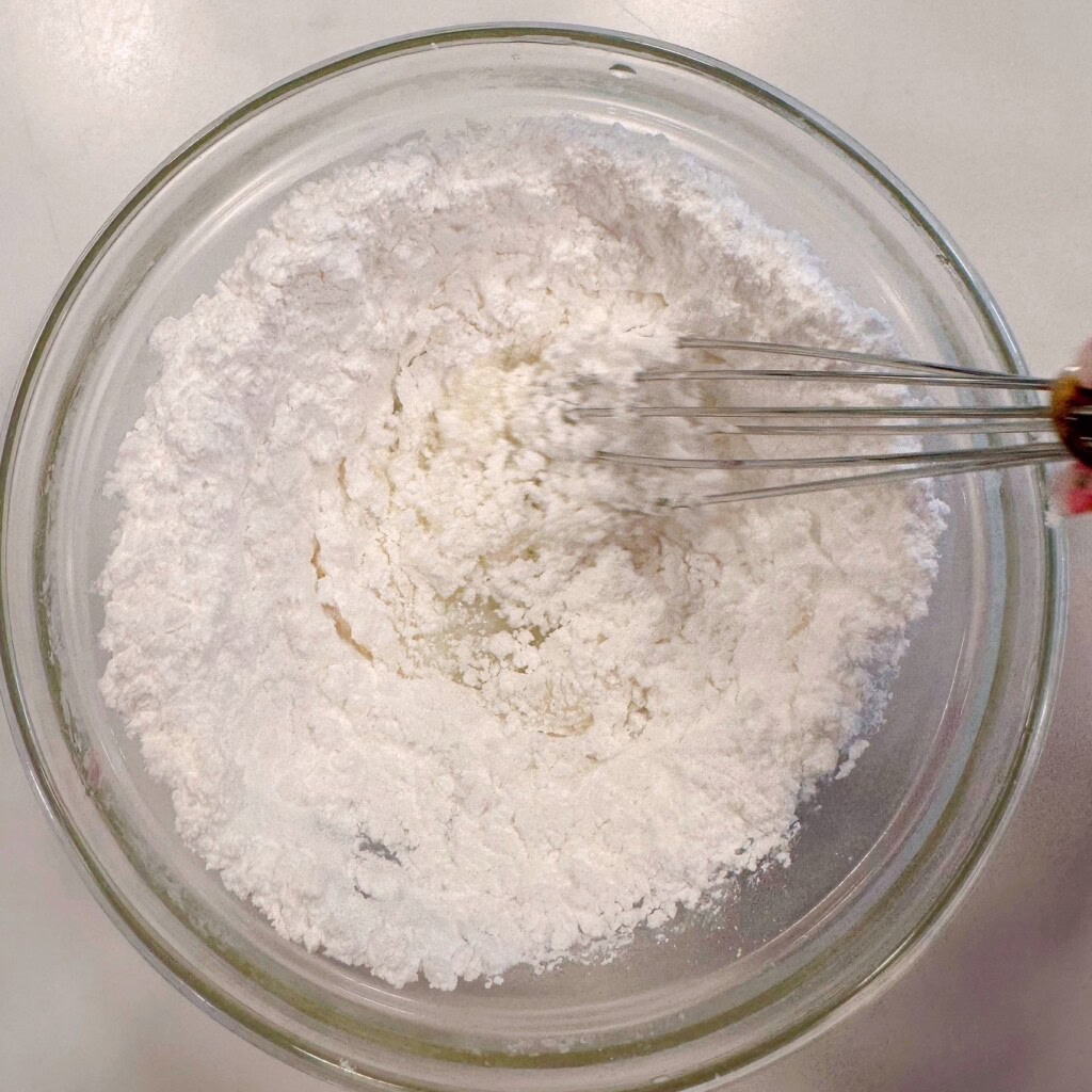 Icing drizzle ingredients in a small bowl with wire whisk.