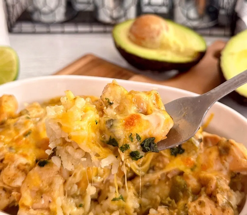 Fork full of chicken chili verde over a bowl full of the same.