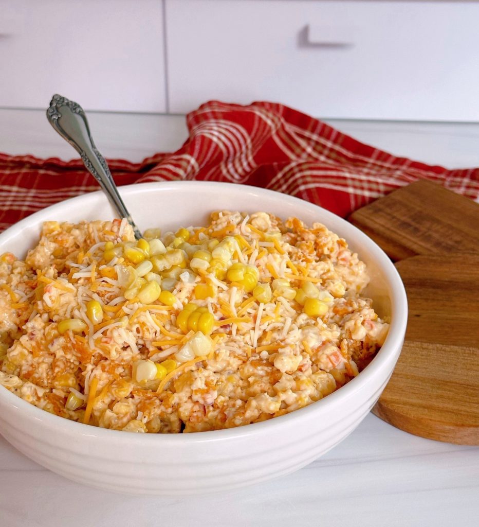 Frito Corn Salad in a white serving bowl with a spoon.