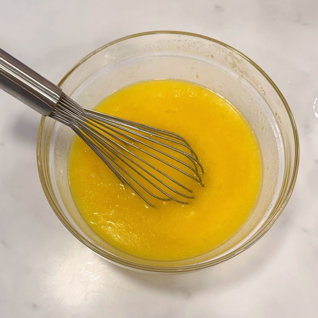Whisk in the eggs to the lemon and sugar.