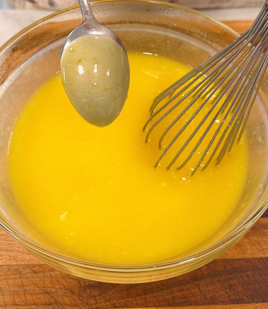 Lemon curd coating the back of a spoon.