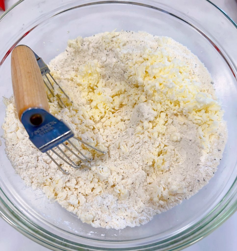 Cutting flour into dry ingredients with a pastry blender.