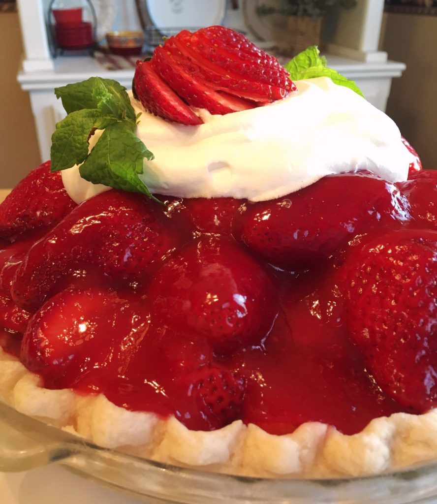 Close-up photo of Strawberry Pie with a dollop of whipped cream and mint