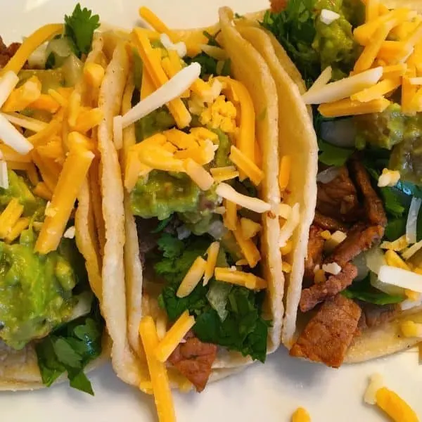 street tacos with guacamole and cheese with carne asada