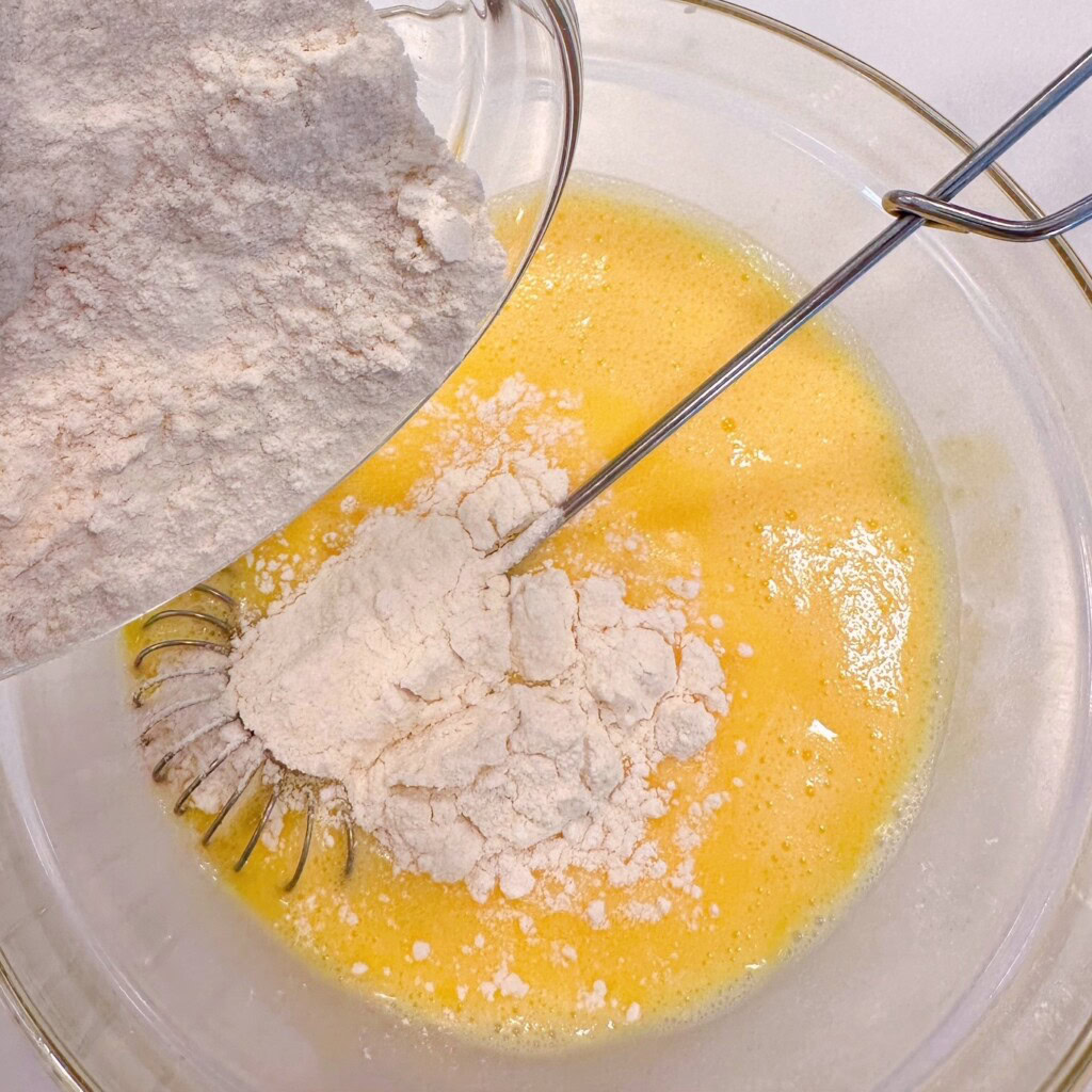 Adding flour and baking powder, and salt to batter.