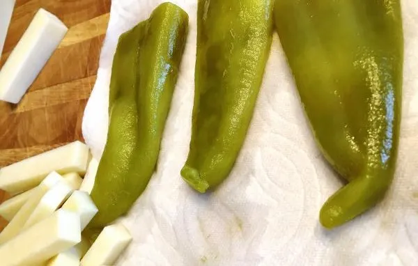 Anaheim Peppers draining on paper towels and cheese sticks to stuff in peppers