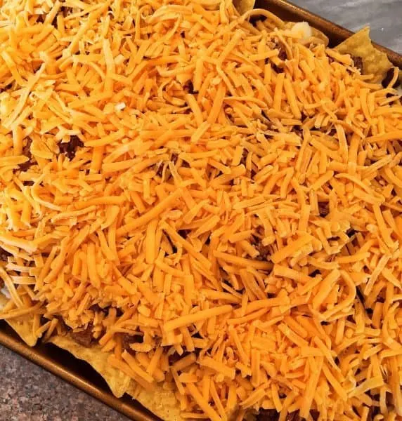 Grated cheddar cheese on top of meat