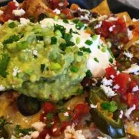 Loaded Nachos in a cast iron skillet.