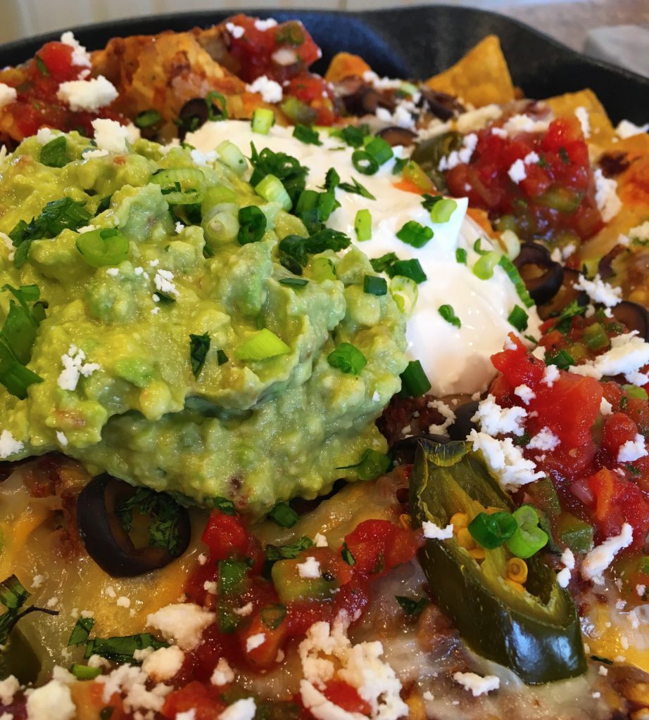 Loaded Nachos in a cast iron skillet.