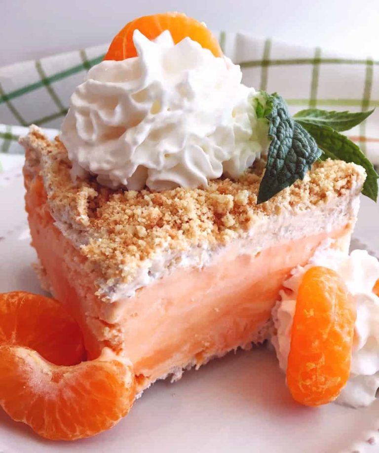 A slice of a creamsicle frozen pie on a plate.