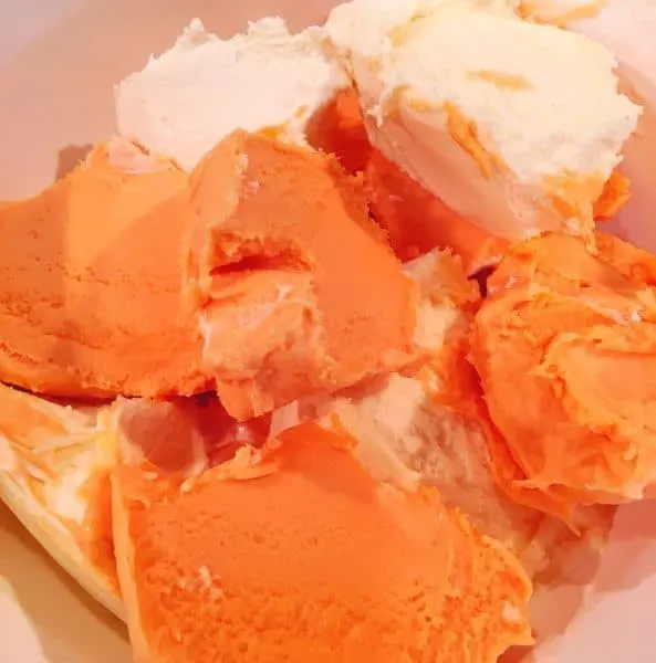 Large bowl with softened Orange Sherbet and Vanilla Ice cream.
