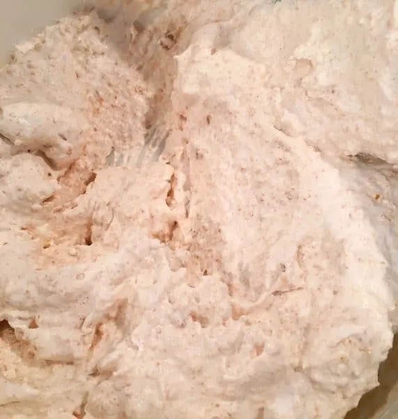 Mixture of cookie crumbs and whipped cream combined and ready to spread in 9 x 13 baking dish.