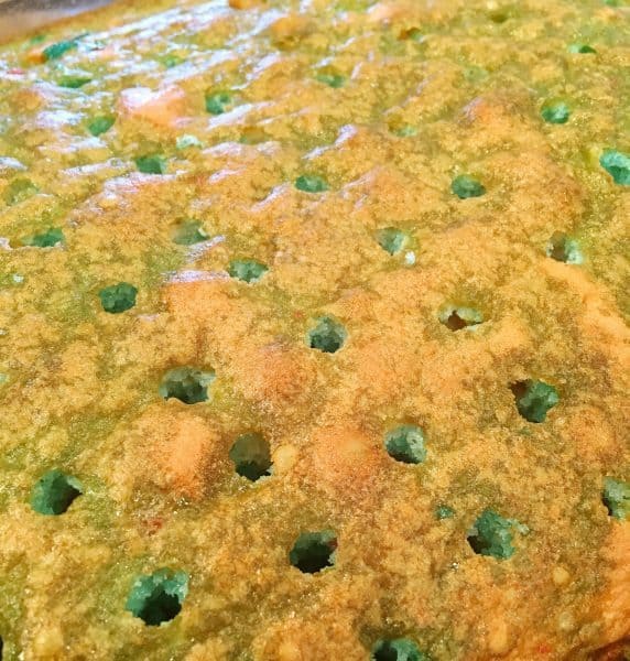 cake with holes and blue jello drizzle in the holes