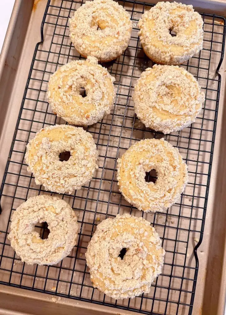 Baked donuts cooling on a rack.