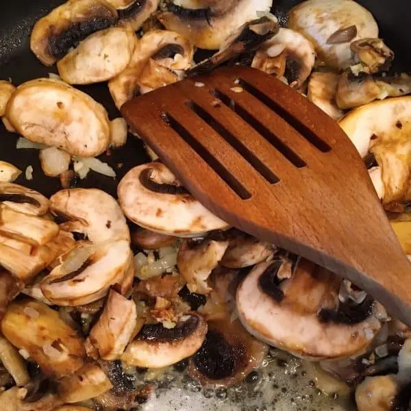 Add sliced mushrooms to onions and garlic