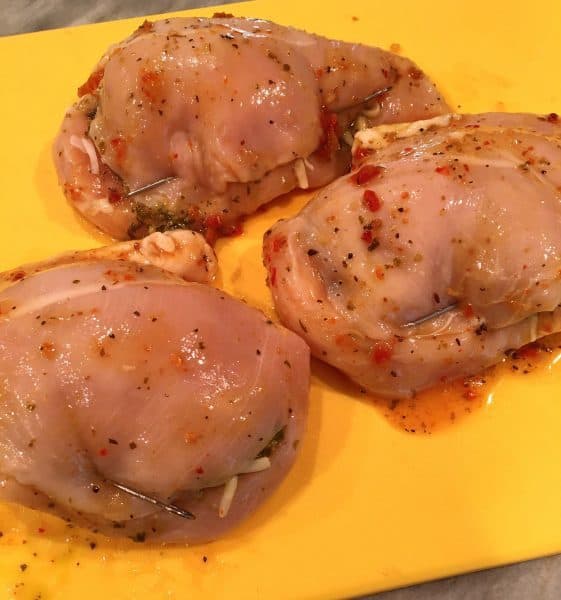chicken breast stuffed and pinned down ready for the grill