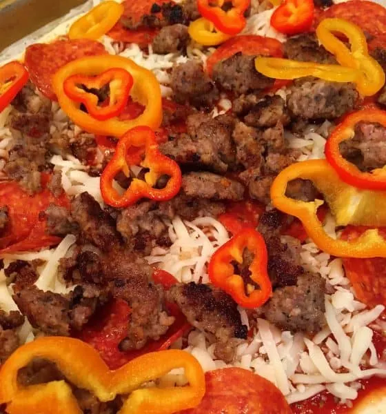 Pizza covered in cheese, sausage, peppers, pepperoni
