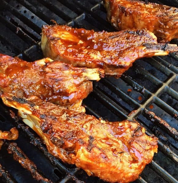 Country pork ribs on the grill with BBQ sauce