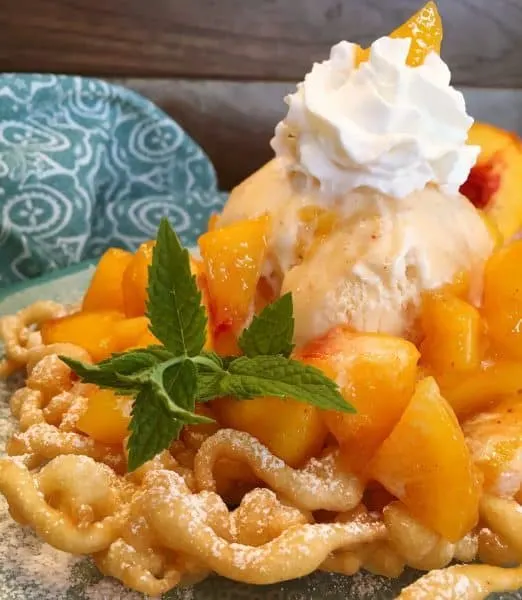 close up of peaches and cream funnel cake