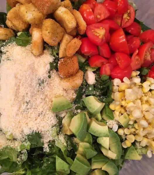 addition of grape tomatoes, avocado, corn, Parmesan cheese, and croutons