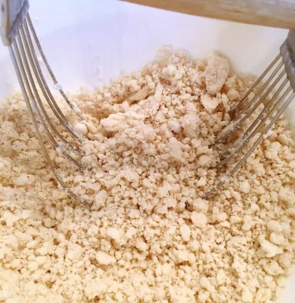 cutting shortening into flour creating a fine crumble