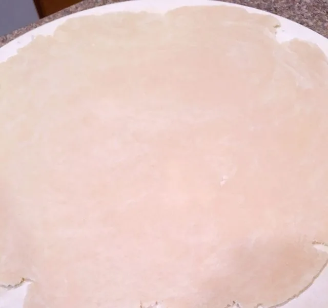 Rolling crust out into a circle on dough disc
