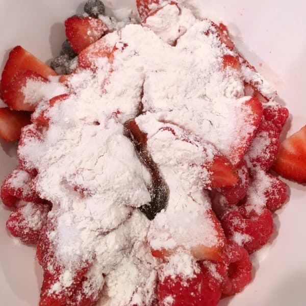 adding sugar and flour to fresh berries