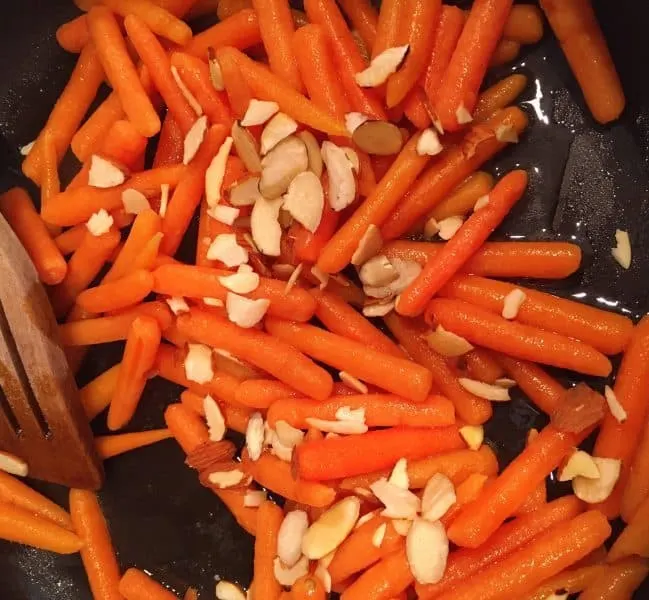 adding slivered almonds to sauteed carrots