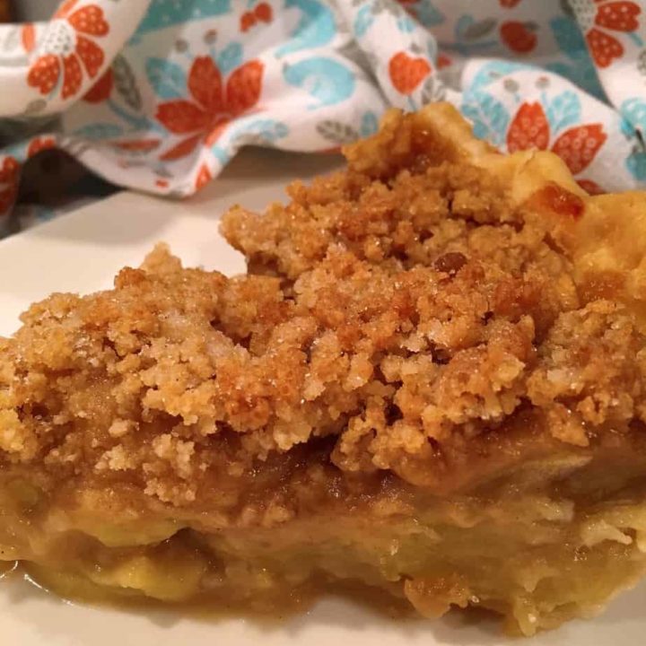 Dutch Apple Pie on a white plate, sliced and ready to eat.