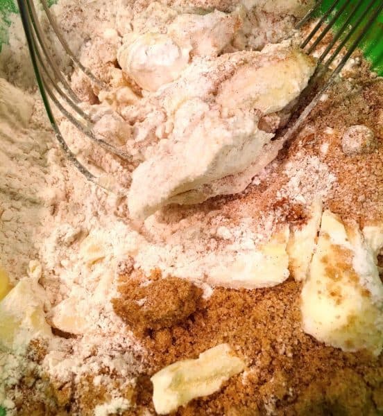 bowl full of crumb toppings with pastry blender to create crumb topping