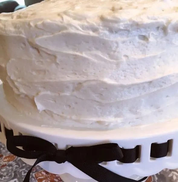 cream cheese frosting on cake on cake plate
