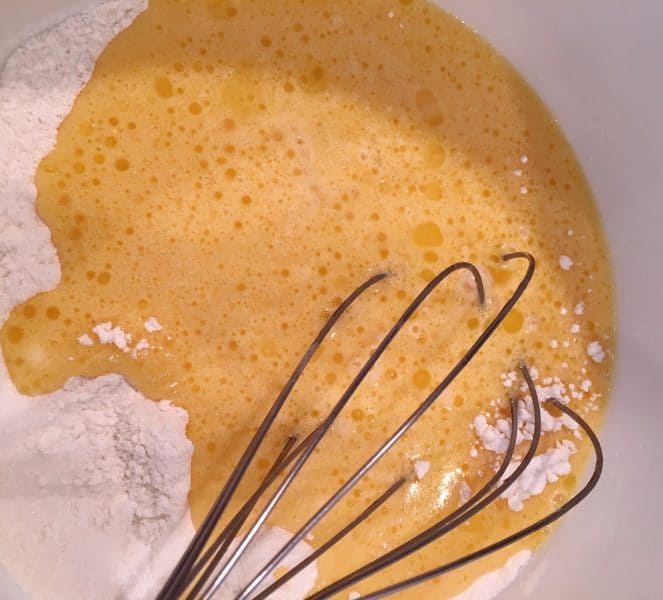 adding wet ingredients to dry cobbler batter