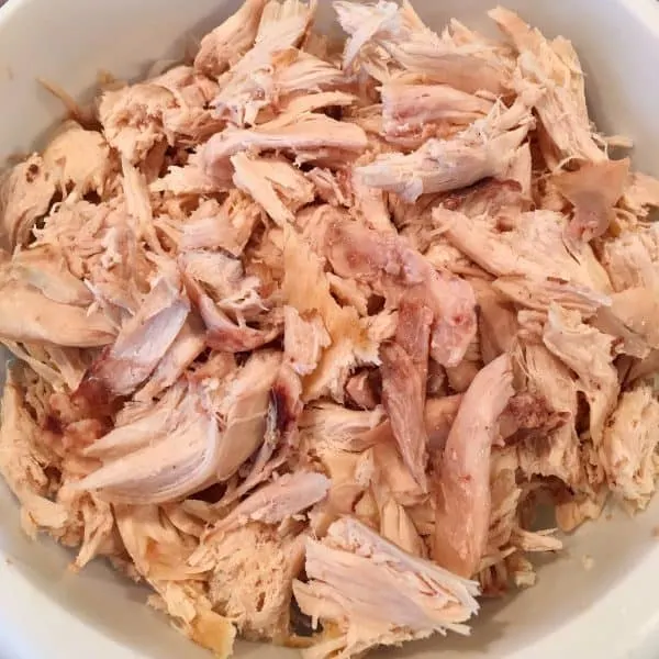 Chicken shredded in a bowl for soup