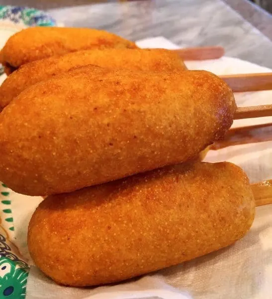 Cooked corn dogs on a paper towel draining after cooking
