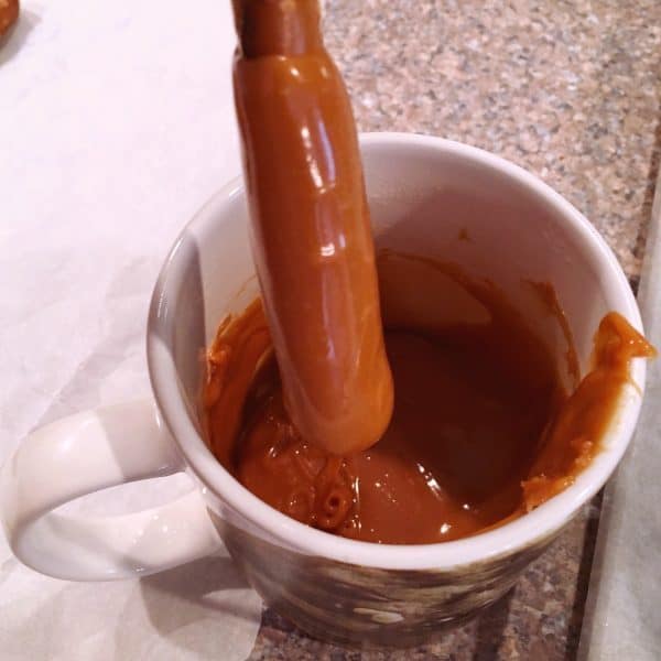 Dipping Pretzel sticks in melted caramel
